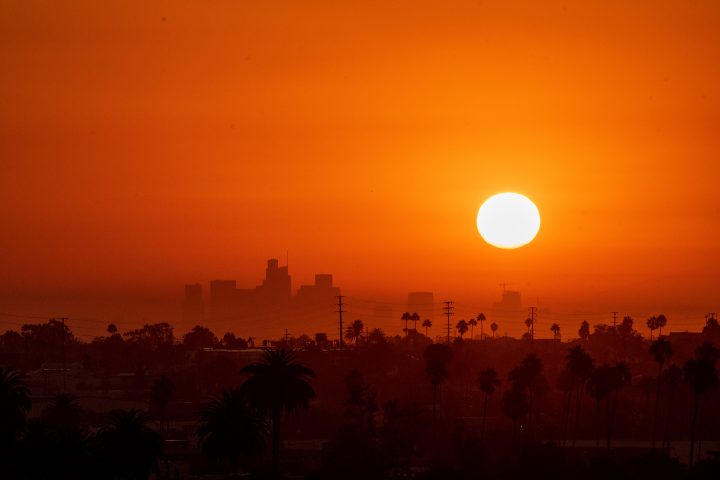 Photo shows the sun in an orange sky.