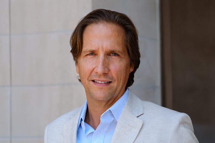 headshot of a white man wearing suit jacket