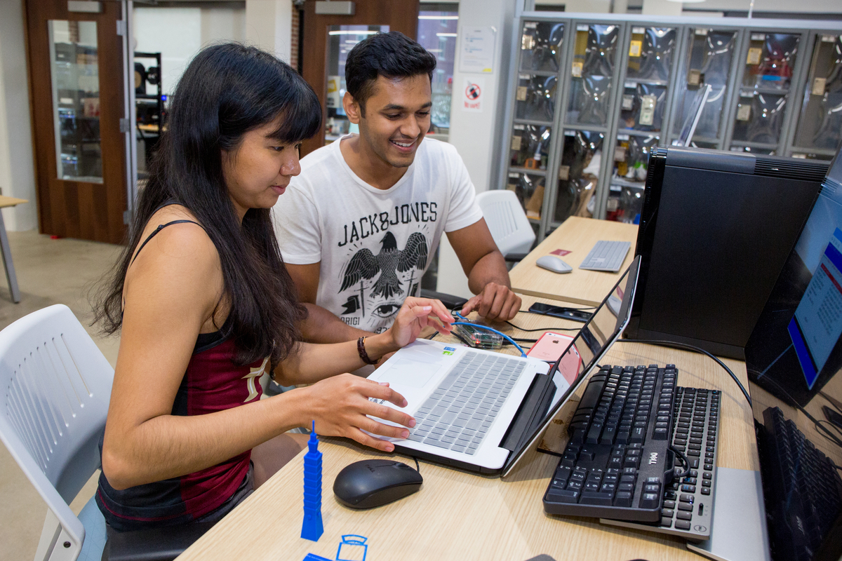 Students working collaboratively on laptops at a workshop table