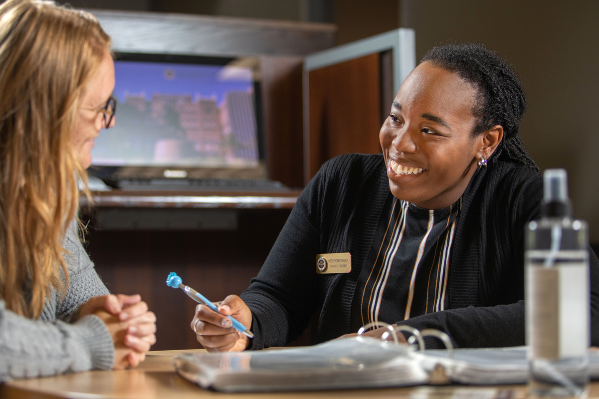 Two individuals conversing across a table in a collaborative workspace