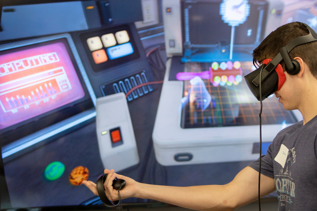 A student interacting with virtual reality equipment in a lab