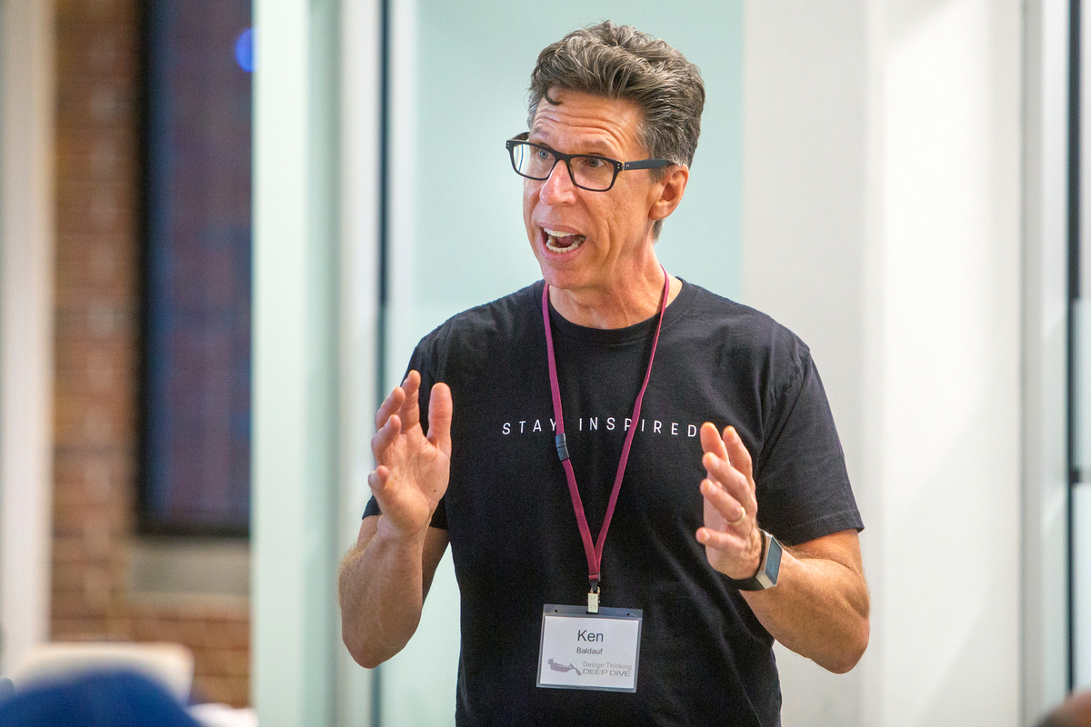 A faculty member gesturing while speaking during a workshop