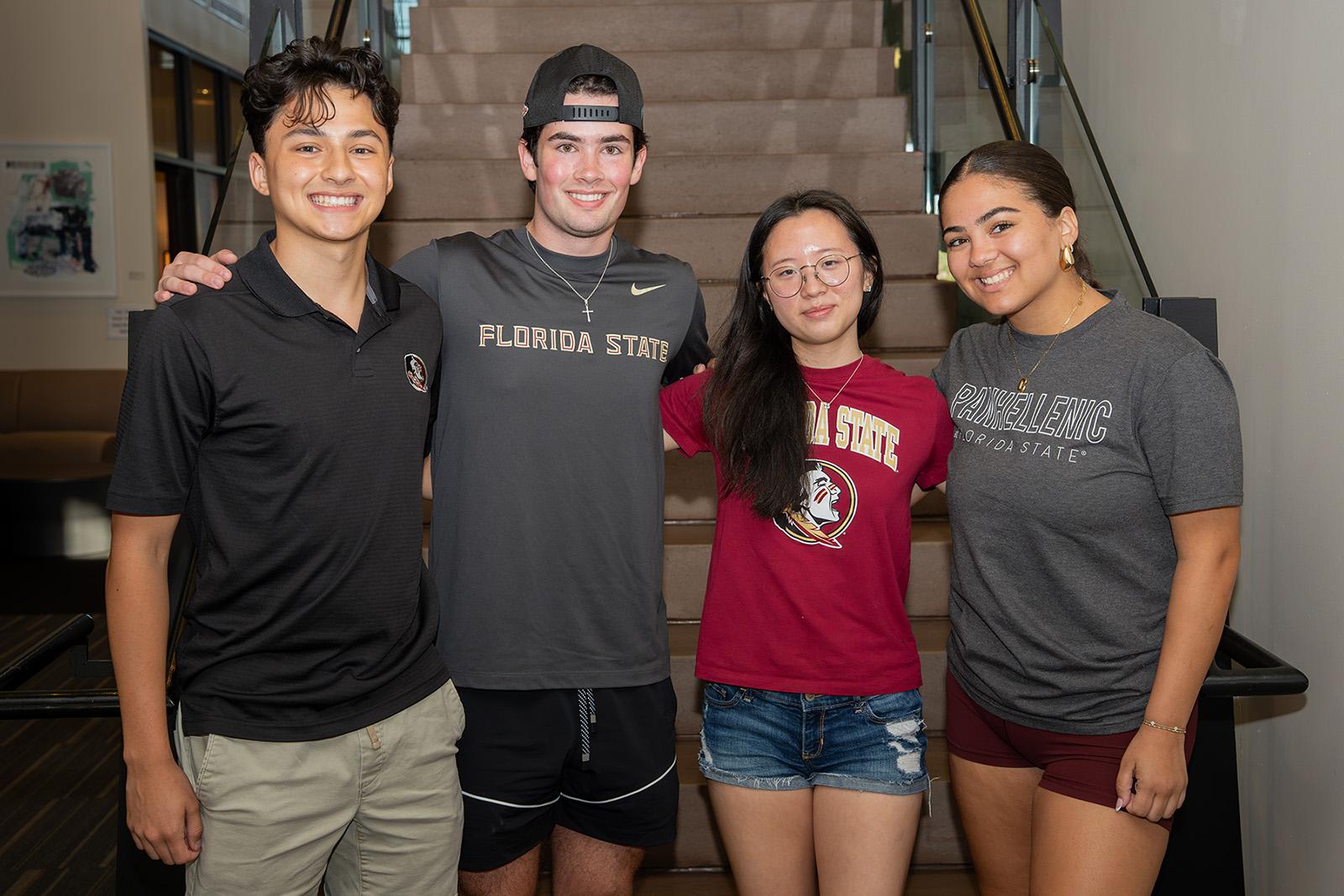Four freshmen students pose in front of a stairwell. 