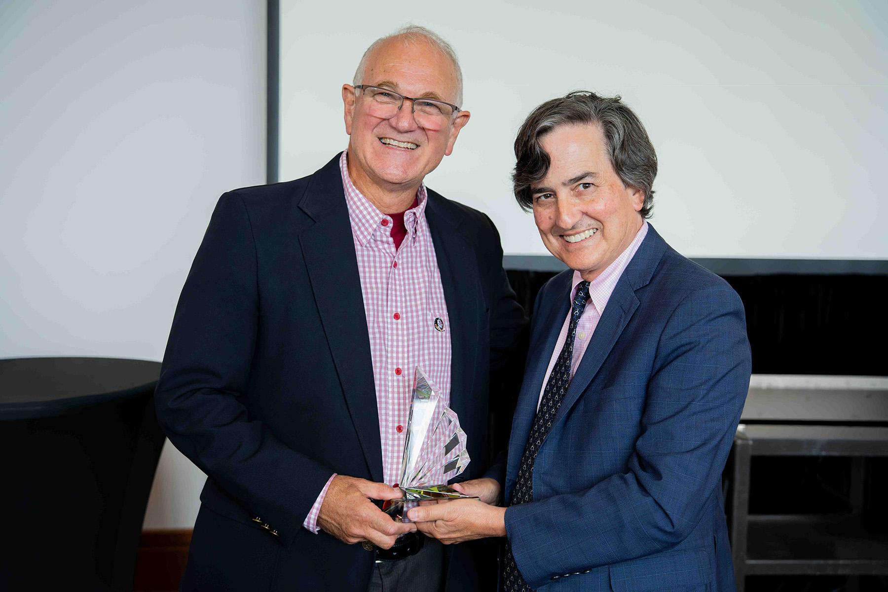John Barnhill, holding the inaugural John C. Barnhill, Jr. Award of Excellence, poses with Provost Jim Clark.  