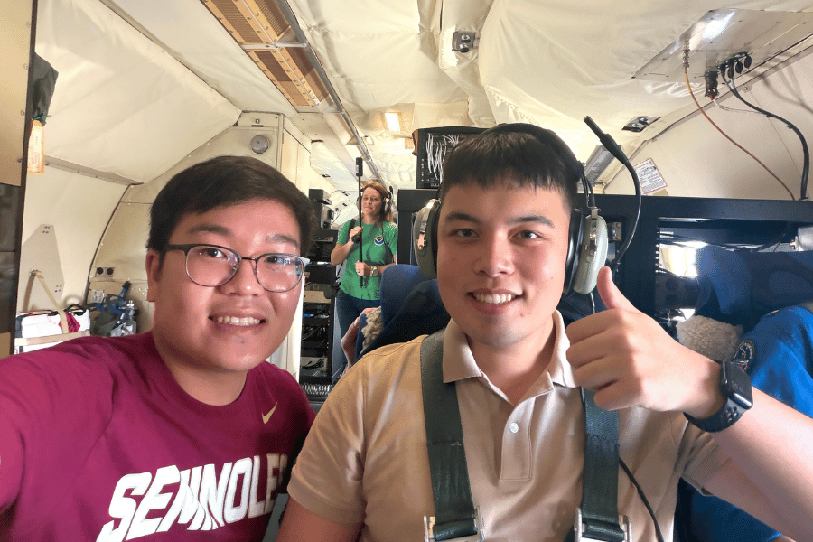 FSU students Tan Dao, left, and Diego Barbero, right, are seated aboard a NOAA P-3 aircraft.